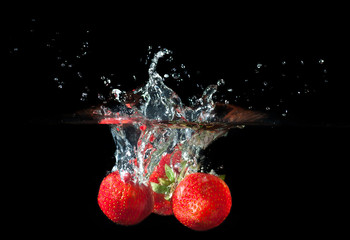 Wall Mural - Strawberries splashing into water