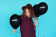 © kegfire - Cheerful fashion girl dancing with black balloons