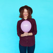 © kegfire - Trendy brunette girl wearing stylish hat, holding a pink balloon