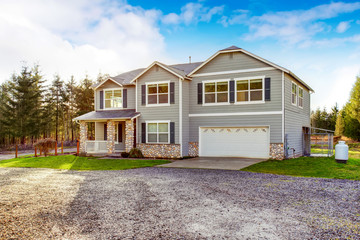 Two level blue country farm house with rocks trim