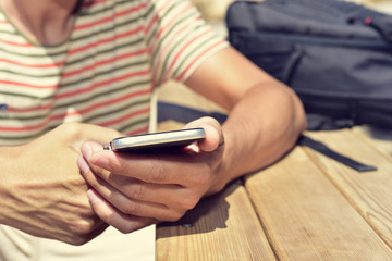 Wall Mural - young man using his smartphone outdoors