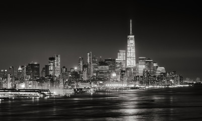Wall Mural - Skyscrapers of New York City Financial District illuminated at night. Aerial panoramic view of Lower Manhattan and the Hudson River in Black & White