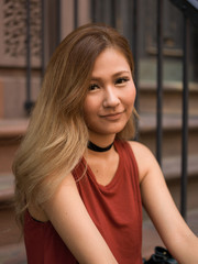 Canvas Print - Young Asian woman in city sitting