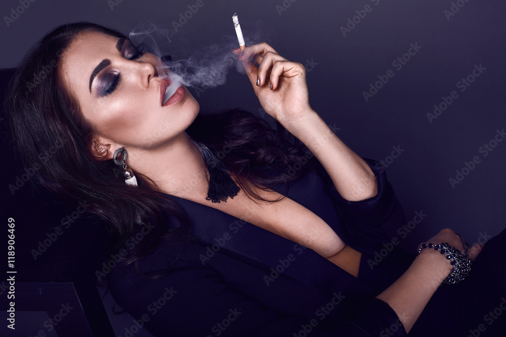 hot cigarette Elegant hot brunette woman smoking a cigarette Stock Photo