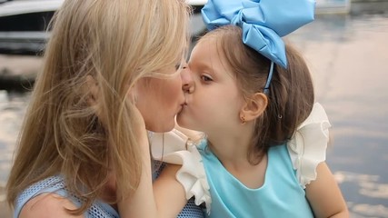 little girl three years sitting on the lap of the mother with long blond hair