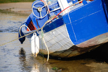 A Blue Fishing Boat At Low Tide