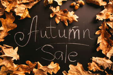 yellow leaves and the words autumn sale on a blackboard vintage style