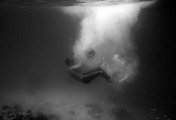 Diver plummet into black ocean with sunlight bubble,black and wh