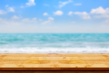 Poster - Empty top of wooden table on blurred beach background.