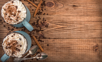 Hot chocolate with whipped cream in mug on a wooden table.