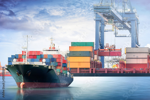 Fotografia Container Cargo ship with working crane bridge w porcie morskim dla lo