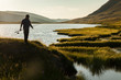 Silhouette of a fisherman with a fishing rod on the background o