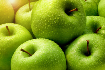 Fresh green apples with rain droplets morning sun.