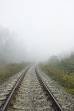 Empty Curved Railroad Track Going Into A Mist. Vertical Comsition.