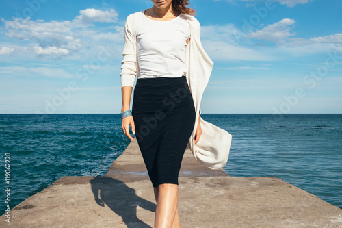 Fotografía Elegant woman in a skirt and cardigan walks on the background of