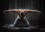 very muscular handsome athletic man striking with a hand on wate