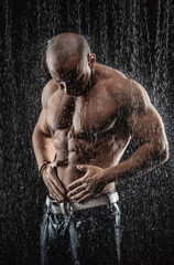 Wall Mural - very muscular handsome athletic man in the rain