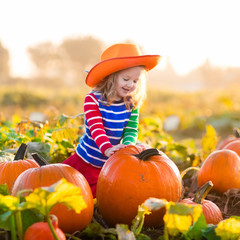 child playing on pumpkin patch