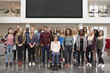 © Monkey Business - Student group standing in atrium under a big AV screen