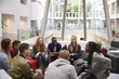 © Monkey Business - Students sitting in the foyer of modern university building