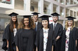 © Monkey Business - Group portrait of university graduates in cap and gown