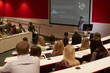 © Monkey Business - Young adult students at a university lecture, back view
