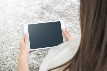 Closeup tablet computer on asian woman hand on blurred gray carp