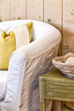 Slipcovered Chair In White With A Striped Pillow. Casual Beach House Setting.