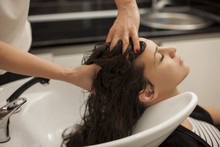Young Woman In A Hair Salon Enjoys While Massaging Her Scalp