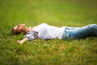 Young woman lying down on grass.She enjoys in the  moment of peace.