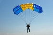 © sergbob - Paraglider flying on colorful parachute in blue clear sky at a bright sunny summer day. Active lifestyle, extreme hobbies