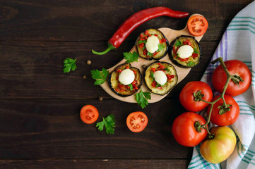 Spicy fried eggplant slices with red pepper, garlic, herbs and mozzarella. The top view.