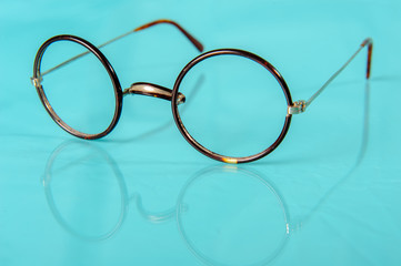 old round glasses on reflective ground