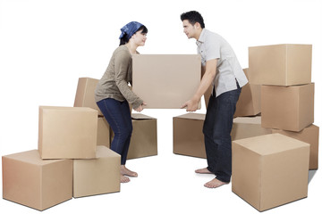 Couple lifting heavy cardboard