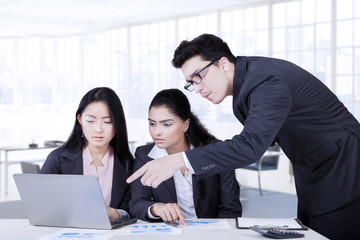 Canvas Print - Man pointing at laptop in business meeting