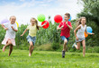 © JackF - Four friendly kids running on green lawn
