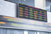 The Currency Exchange Rates Displayed At The Toronto Stock Exchange With Stock Ticker In Blurred Motion Underneath.