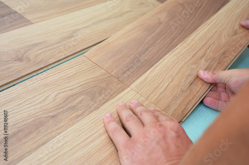 Fotografia, Obraz Installing laminate flooring fitting the next piece