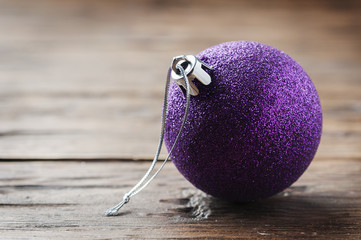 Wall Mural - Christmas card with purple ball on the wooden table