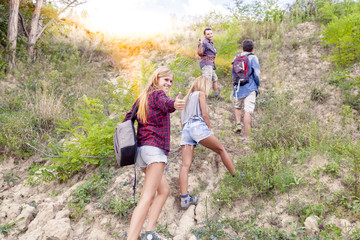 group of young hikers walking toward the horizon over the mounta