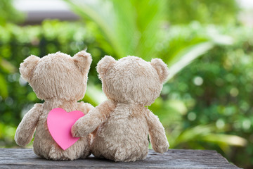 valentines concept, teddy bear with paper heart on wooden natur