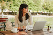 © Jacob Lund - Young woman relaxing at outdoor coffee shop
