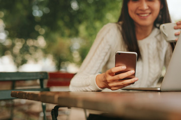 young woman in a cafe using mobile phone