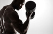 © Jacob Lund - Young african man working out with dumbbells