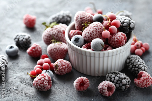 Fotografia  Frozen berries on a black wooden table
