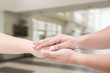 © MIND AND I - Hand of medical doctor carefully holding patient's hands.