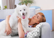 © Africa Studio - Girl with Samoyed dog on couch