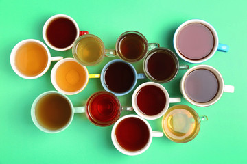 Poster - Cups of tea on green background, top view