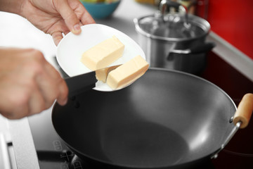 Sticker - Female hand putting butter in pan closeup