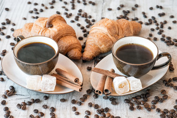 Wall Mural - Cup of coffee with grains, croissant, turkish delight and cinnamon sticks on wooden background